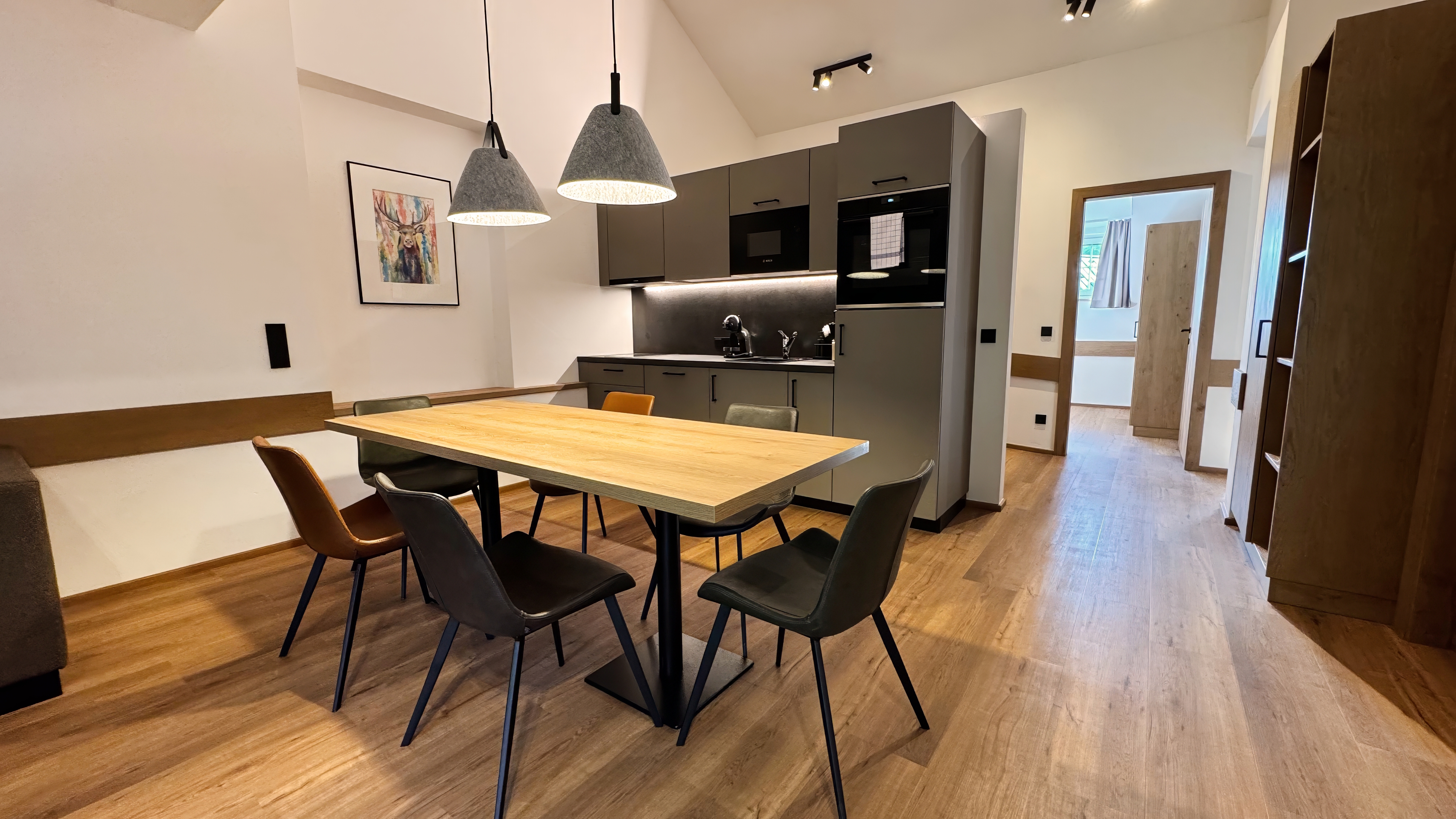Wohnbereich der Ferienwohnung mit TV, Esstisch und Holzdetails