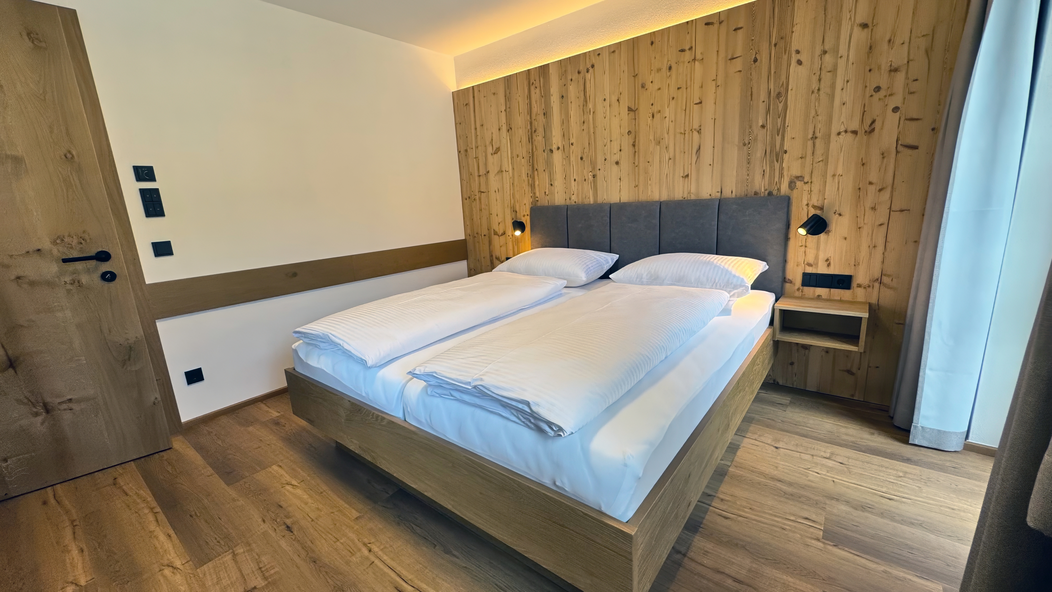 Wohnbereich der Ferienwohnung mit Sofa, TV und offener Küche